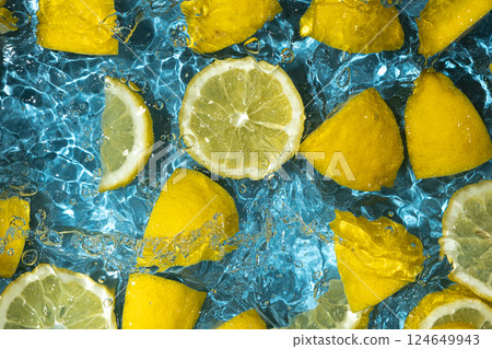 Juicy lemon background of halves and slices of fresh lemons in water. 124649943