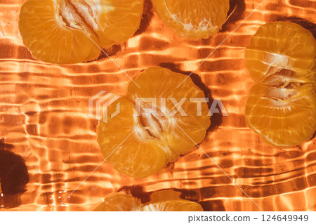 Peeled fresh mandarin halves in water, splash water, top view 124649949