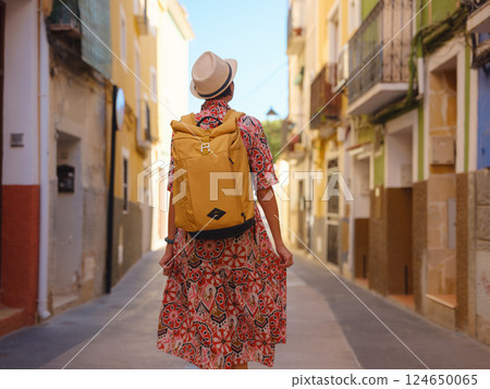 Woman strolls through colorful streets of Spanish coastal town Woman strolls through colorful streets of Spanish coastal town 124650065