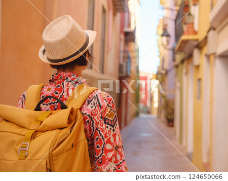 Woman strolls through colorful streets of Spanish coastal town Woman strolls through colorful streets of Spanish coastal town 124650066