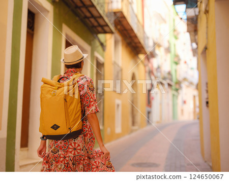 Woman strolls through colorful streets of Spanish coastal town Woman strolls through colorful streets of Spanish coastal town 124650067
