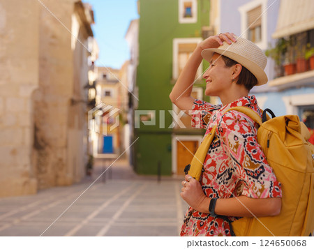 Woman strolls through colorful streets of Spanish coastal town Woman strolls through colorful streets of Spanish coastal town 124650068