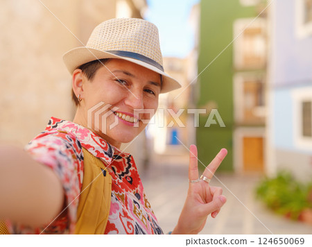 Woman strolls through colorful streets of Spanish coastal town 124650069