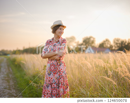 boho chic woman in a floral dress in European countryside boho chic woman in a floral dress in European countryside 124650078