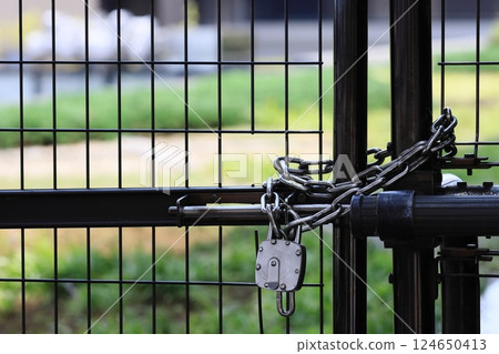 A securely locked fence and a chained entrance 124650413