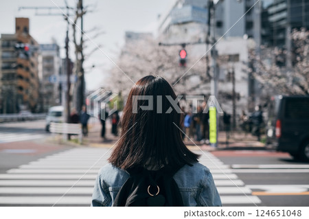 Back view of a woman walking down the street in spring Back view of a woman walking down the street in spring 124651048