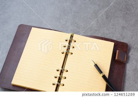 某人打開環形筆記本進行辦公桌工作的圖像 124651289