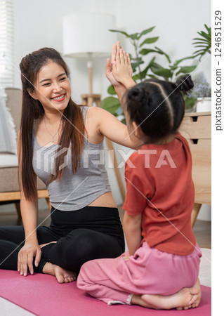 Fitness and Bonding. A mother and her daughter engage in a playful exercise session. 124651529