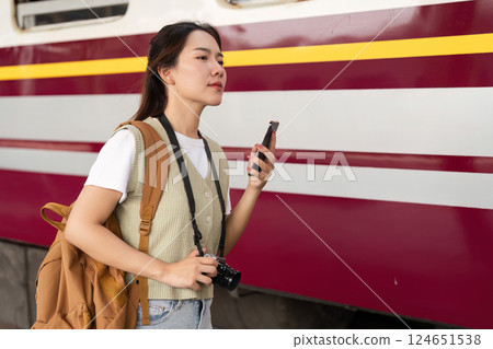 Journey and Connection. A woman interacting with her digital devices while waiting for the train. Journey and Connection. A woman interacting with her digital devices while waiting for the train. 124651538