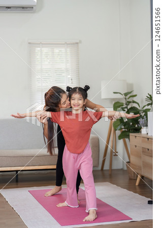 Fitness and Bonding. A mother helping her daughter with yoga exercises at home. Fitness and Bonding. A mother helping her daughter with yoga exercises at home. 124651566