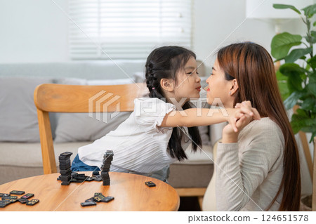 Family Connection and Affection. A mother and daughter share a playful moment during a game of dominoes. Family Connection and Affection. A mother and daughter share a playful moment during a game of dominoes. 124651578