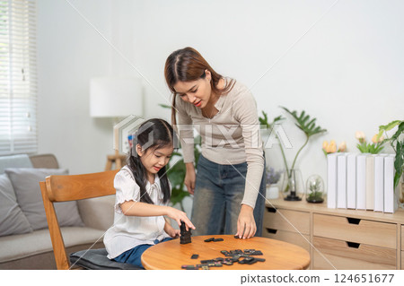 Mother-Daughter Moments and Discovery. A playful game session encourages learning and bonding in a serene environment. Mother-Daughter Moments and Discovery. A playful game session encourages learning and bonding in a serene environment. 124651677