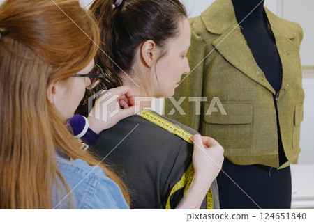 Atelier sewing workshop. female seamstress, fashion designer, takes measurements . Atelier sewing workshop. female seamstress, fashion designer, takes measurements . 124651840