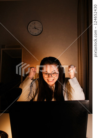 Cheerful millennial woman enjoy videocall with friends using laptop. Gesturing and smiling. Talking with friends who living far. Cherishing long distance friendship. 124652430