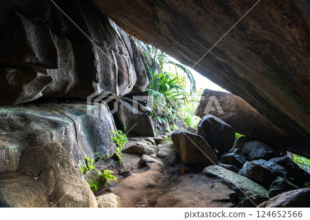 Granite cave with boulders and tropical vegetation along Anse Major Trail on Mahe island, Seychelles 124652566