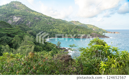 Tropical coastal trail view with granite rocks, lush jungle, and ocean horizon in Seychelles 124652567