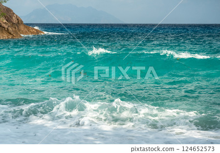 Vibrant turquoise ocean waves rolling onto the shore at Anse Major, Mahe island, Seychelles Vibrant turquoise ocean waves rolling onto the shore at Anse Major, Mahe island, Seychelles 124652573