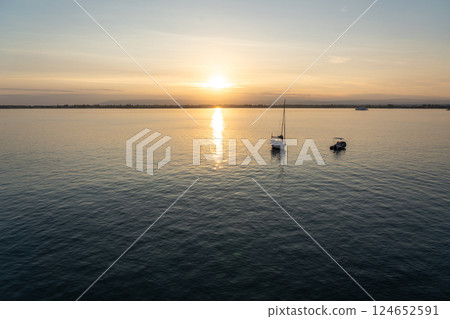 Sunset over the ocean, with the sun low on the horizon, contrast between sky and sea Sunset over the ocean, with the sun low on the horizon, contrast between sky and sea 124652591