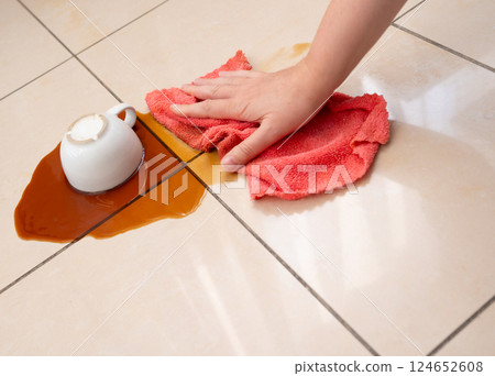 Spilled coffee, coffe puddle stain on tiled floor, messy leak with fallen cup, brown drink spillage Spilled coffee, coffe puddle stain on tiled floor, messy leak with fallen cup, brown drink spillage 124652608