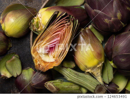 Plate full of cut purple raw artichokes top view. Fresh italian vegetables from farmers market 124653491