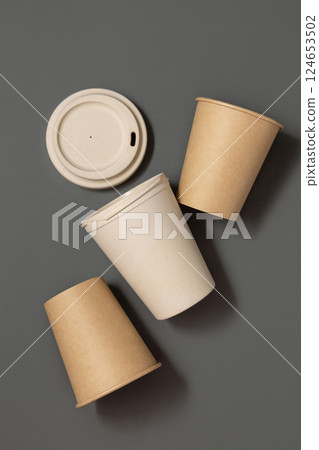 New beige kraft paper cups and reusable bamboo coffee cup on a gray top view, mockup New beige kraft paper cups and reusable bamboo coffee cup on a gray top view, mockup 124653502