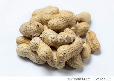 Pile of unpeeled peanuts in shell close-up on white background. Pile of unpeeled peanuts in shell close-up on white background. 124653992