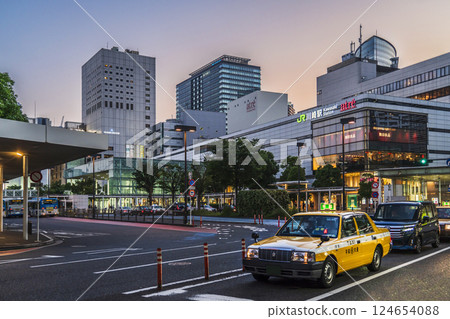 Urban scene in front of JR Kawasaki Station: A taxi driving through the streets of Kawasaki at dusk [Kawasaki City, Kanagawa Prefecture] 124654088