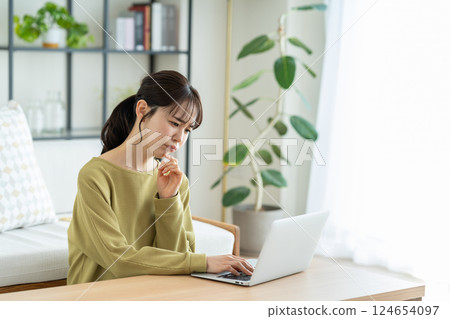 Young woman using a computer in the living room Young woman using a computer in the living room 124654097