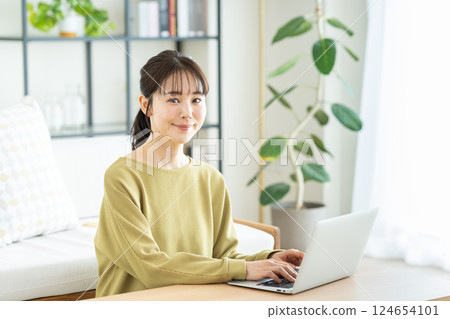 Young woman using a computer in the living room 124654101
