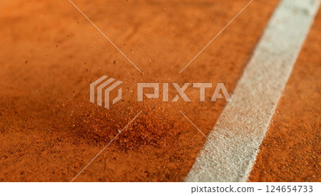 Freeze Motion Detail Shot of Tennis Ball Hitting a Clay Court 124654733