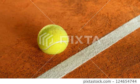 Freeze Motion Detail Shot of Tennis Ball Hitting a Clay Court 124654744