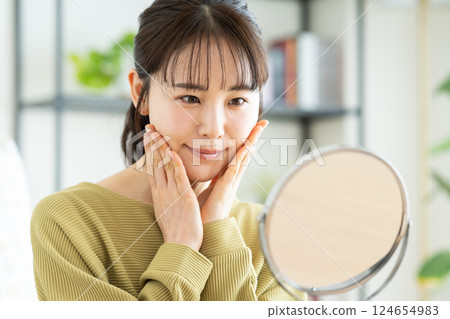 客廳裡照鏡子的年輕美女 124654983