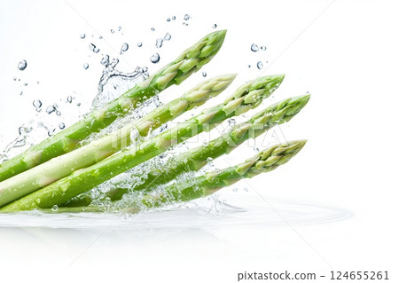 Fresh green asparagus spears splashing in water. Fresh green asparagus spears splashing in water. 124655261