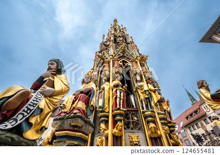 Nuremberg, Germany, August 1, 2023. Iconic shot of the magnificent fountain in the market square. Details of the fountain's many golden statues. Travel destinations. 124655481