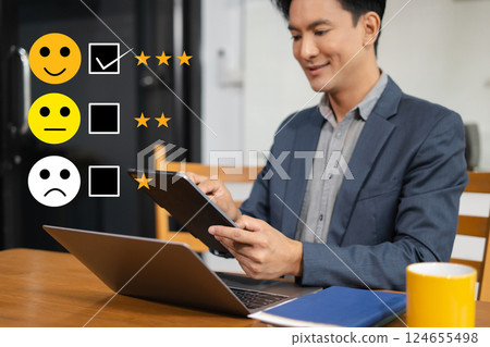 Male businessman holding a digital tablet with checkboxes rating smiley faces excellent for Satisfaction Survey, Happy Client Customer Experience concept. Male businessman holding a digital tablet with checkboxes rating smiley faces excellent for Satisfaction Survey, Happy Client Customer Experience concept. 124655498