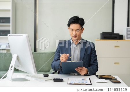 Mature businessman calculate and analyzing graph document financial with report and laptop in office. 124655529