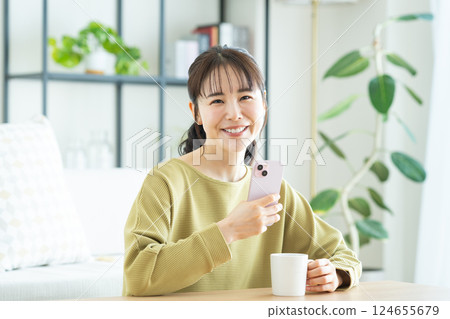 Young woman looking at her smartphone in the living room 124655679