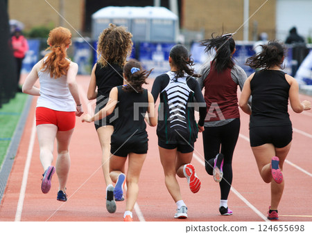 Young Women Running on a Track During an Athletic Event 124655698