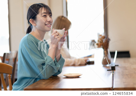 A young woman drinking coffee at a cafe 124655834