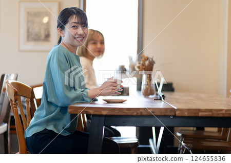 在咖啡館的一個少婦飲用的咖啡 124655836