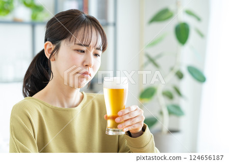 Young woman drinking beer in the living room 124656187