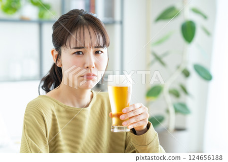 年輕女子在客廳喝啤酒 124656188