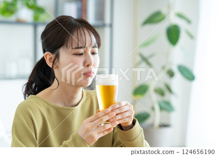 Young woman drinking beer in the living room 124656190