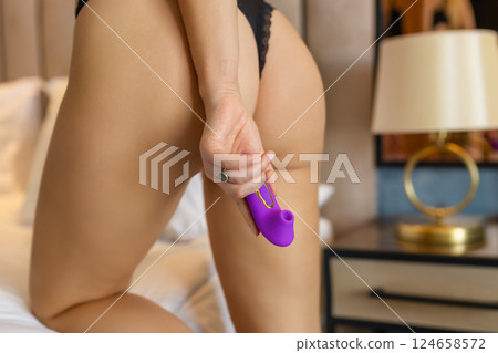 A slender woman holds a dildo in her hand. Toys for adults. 124658572
