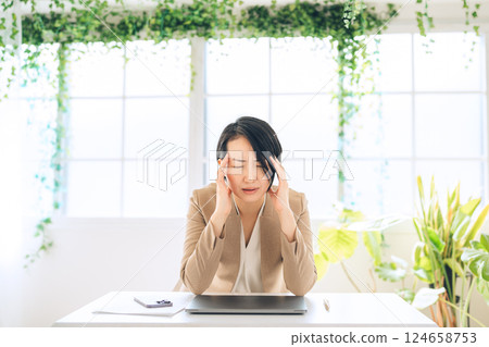 一位中年女性擔心自己的辦公室看起來不自然 一位中年女性擔心自己的辦公室看起來不自然 124658753