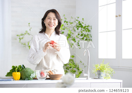 在廚房裡做飯的中年女人 在廚房裡做飯的中年女人 124659123