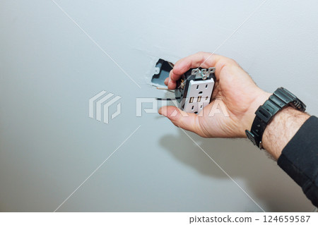 Electrician works on installing new outlet with USB ports in home interior during renovation works Electrician works on installing new outlet with USB ports in home interior during renovation works 124659587