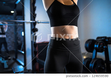 Woman stretching her stomach at the gym, muscle training girl 124659590