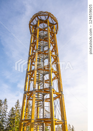 Svetly vrch lookout tower in Albrechtice stands tall against a clear sky. Visitors can climb its spiral staircase to enjoy breathtaking panoramas of the surrounding Jizera Mountains. 124659605