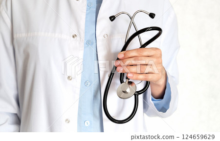 Healthcare professional taking notes in a clinical setting during a routine check-up 124659629